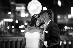 Black and white intimate wedding portrait against city lights.