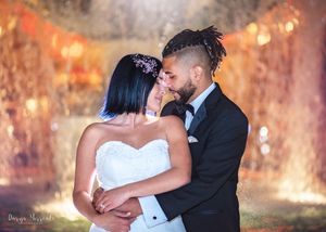 Wedding portrait with glowing fountain backdrop showing intimate moment between newlyweds.