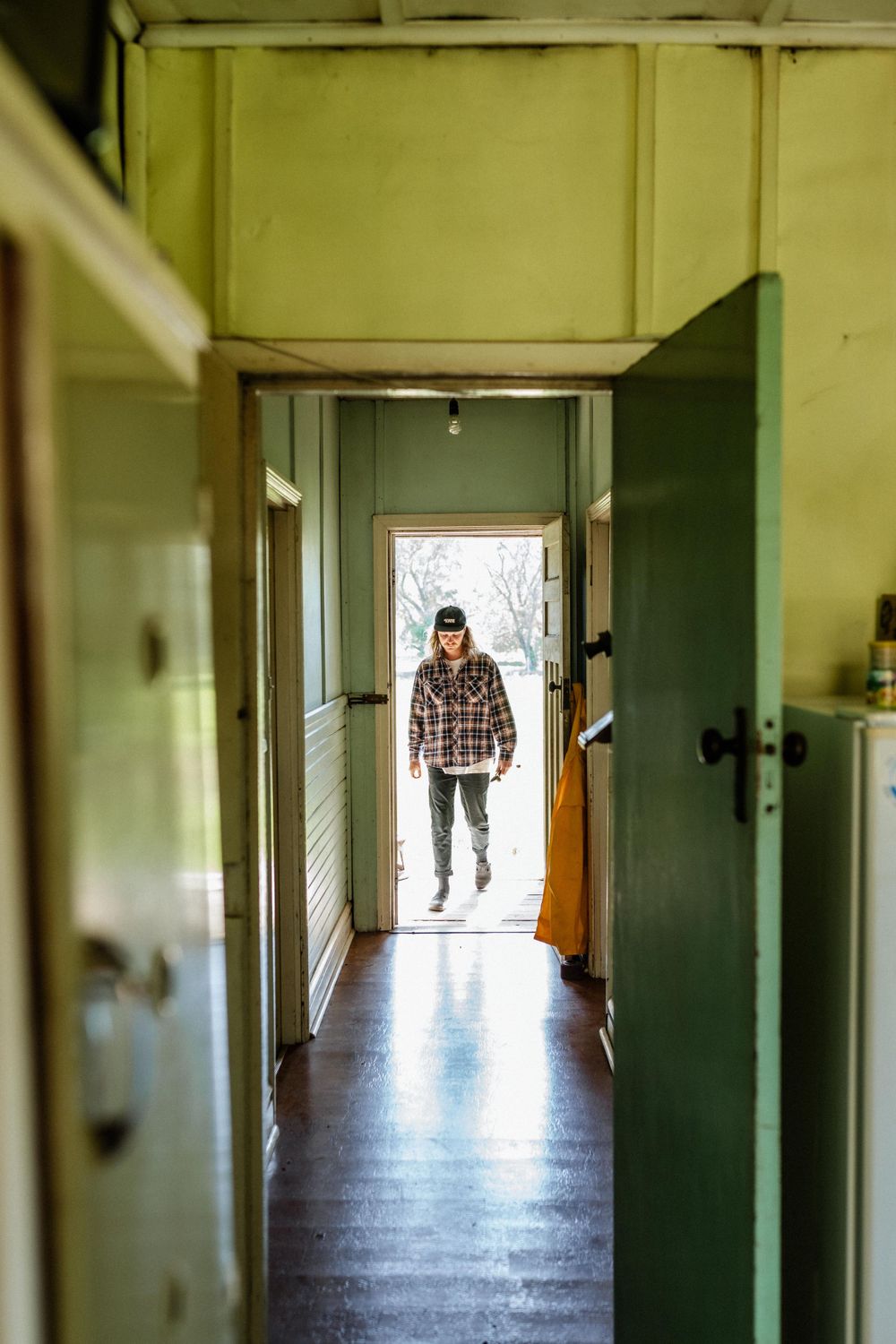 A man walking into an old cottage home