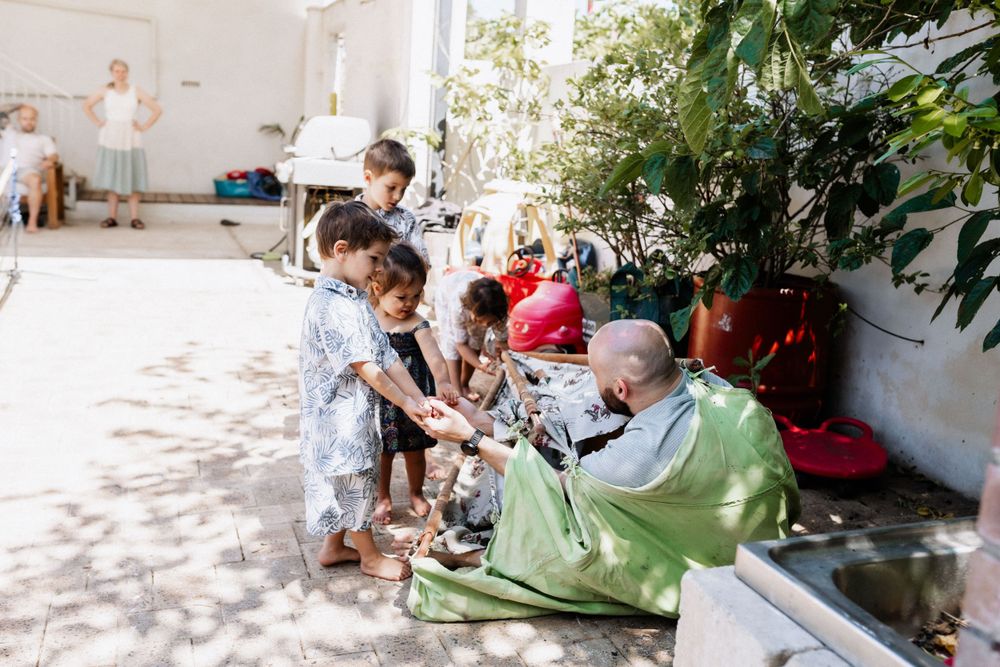 Cousins playing chases with their uncle during an extended family photo session in Perth