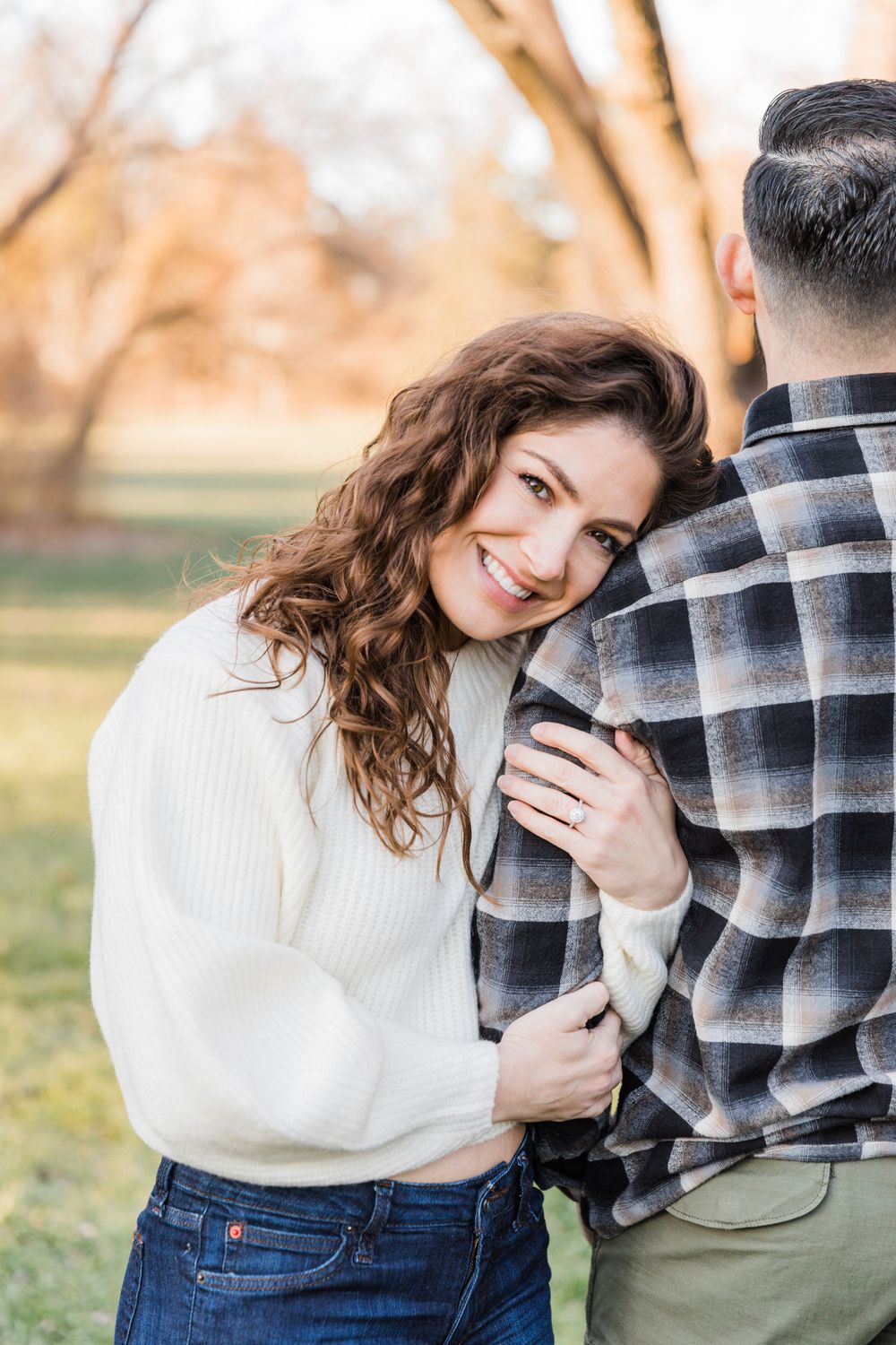 Romantic couple in cozy autumn outfits sharing an intimate moment outdoors with soft natural lighting.