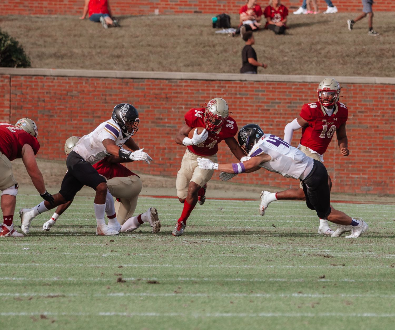College football players collide during an intense rushing play on the field.