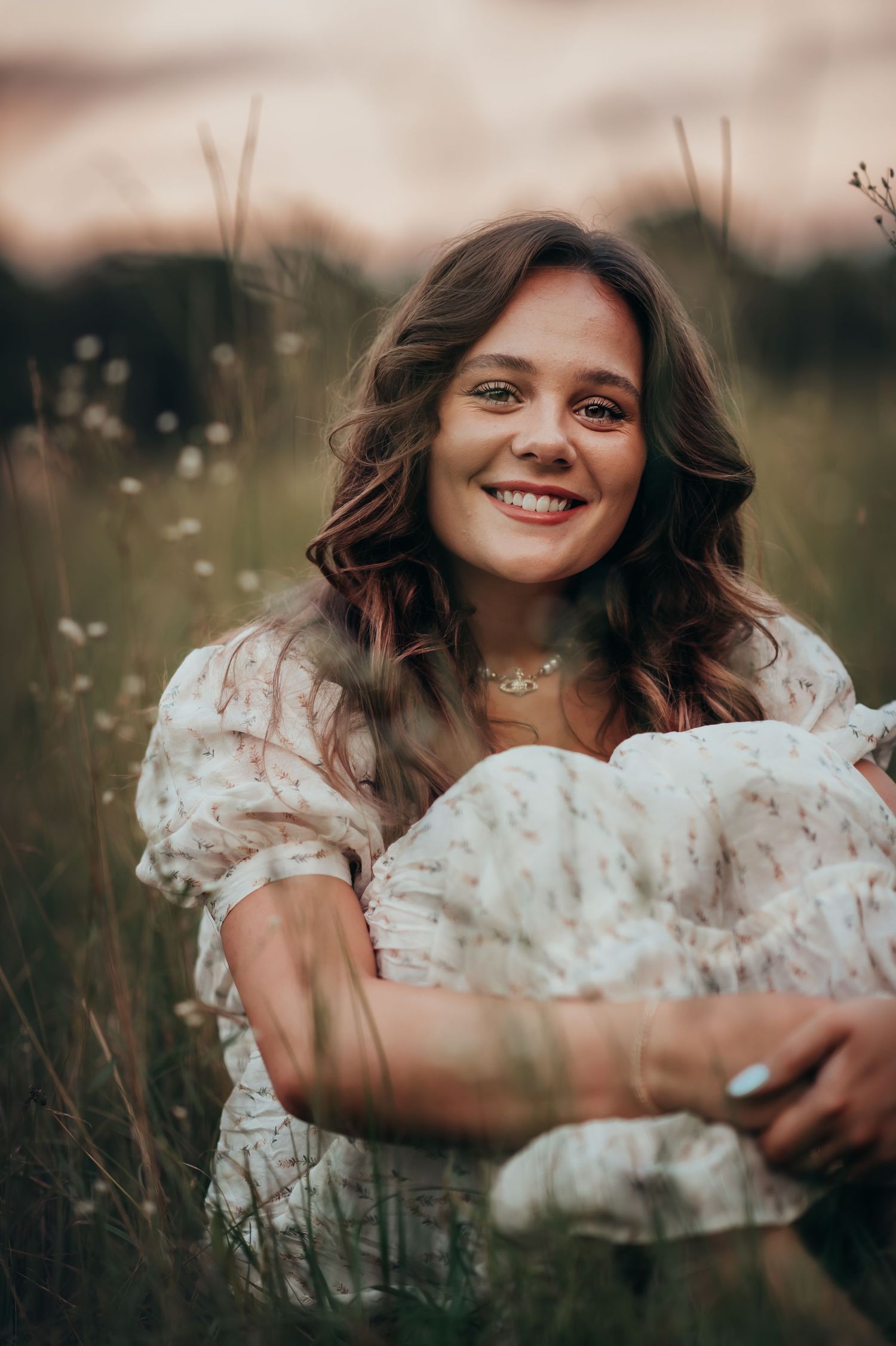 A young woman sitting in a field of wildflowers at Chickamauga Battlefield with a smile on her face.