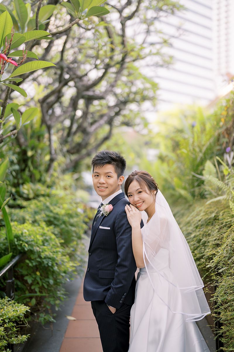 Couple enjoys playful moment in urban rooftop garden surrounded by greenery.