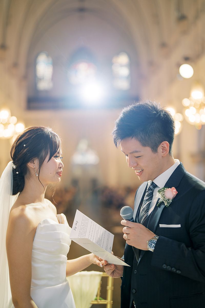 Wedding ceremony moment in an ornate church with warm ambient lighting.