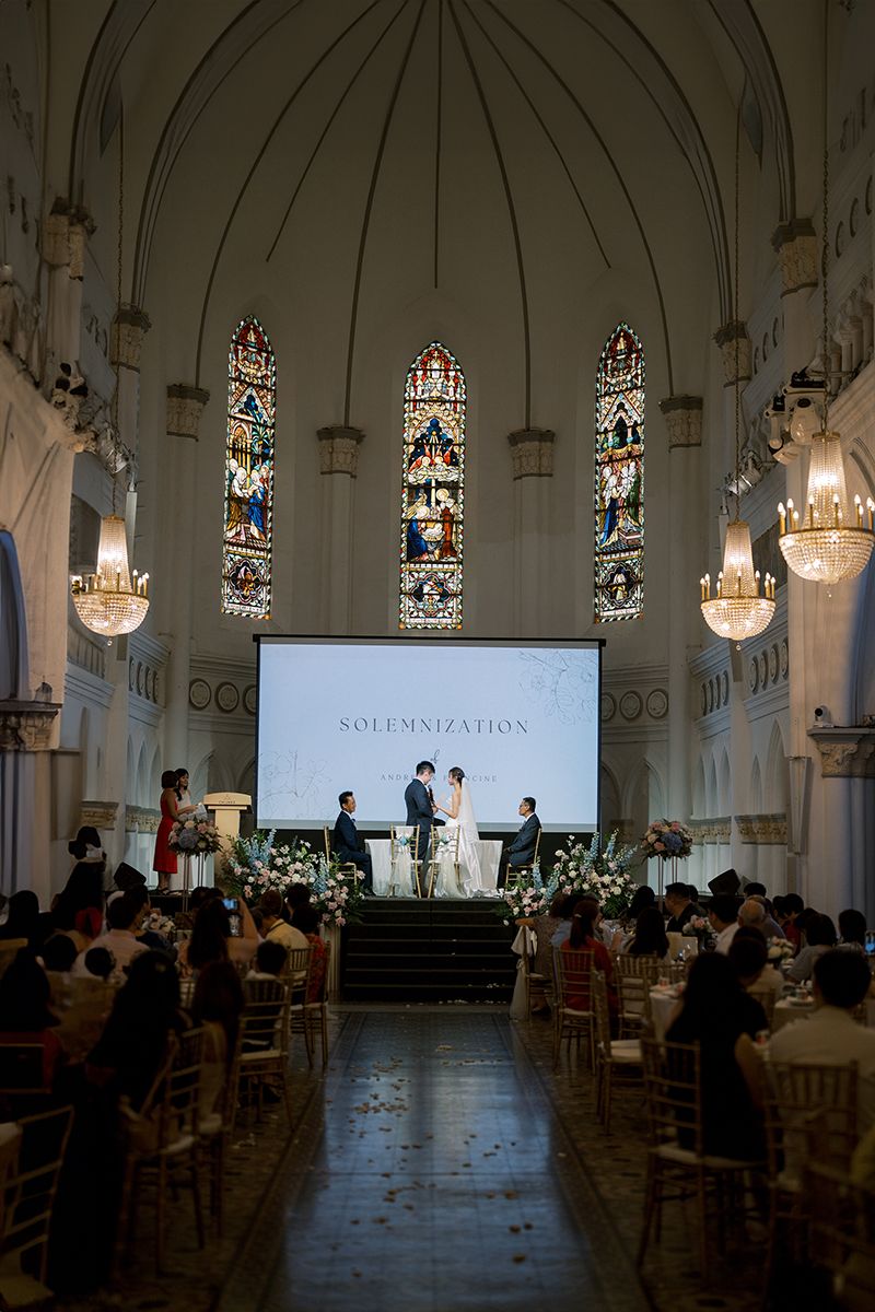 Church wedding venue with gothic architecture, stained glass windows, and dramatic lighting.