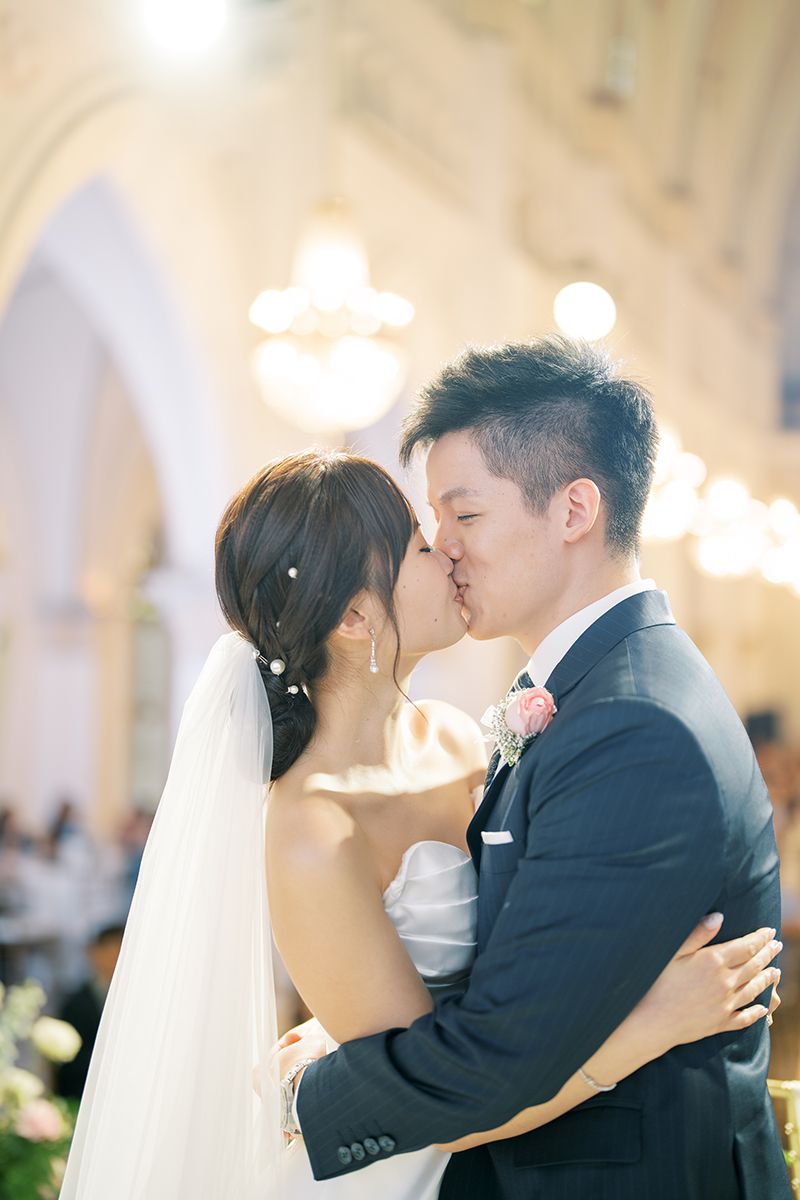 Romantic wedding moment captured in a beautifully lit church setting.