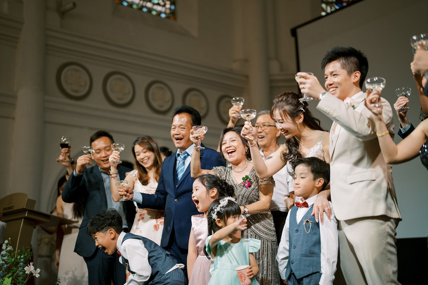 Wedding celebration with guests cheering and clapping in an elegant venue.