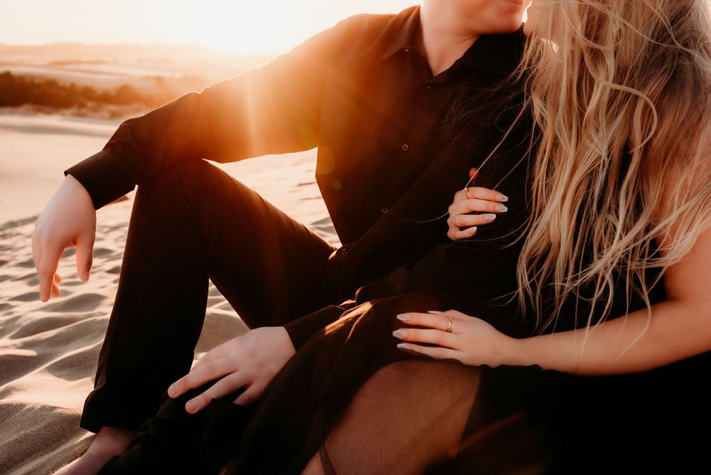 Intimate beach portraits bathed in warm sunset lighting capture tender embraces.