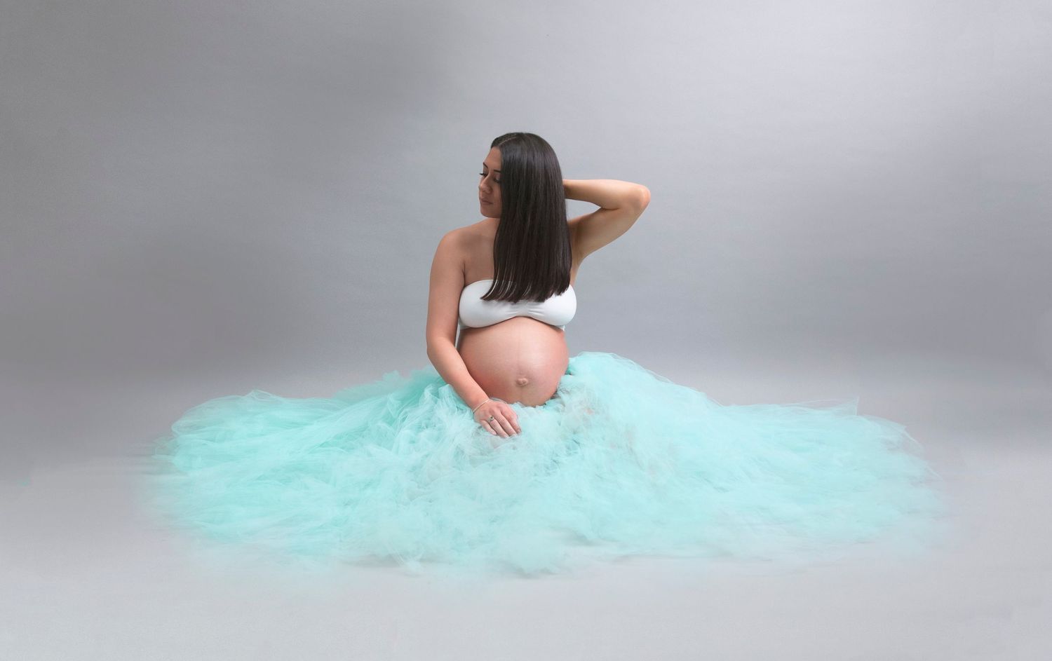 Elegant Maternity Shoot, Grey Backdrop, mum to be wearing turquoise tulle skirt
