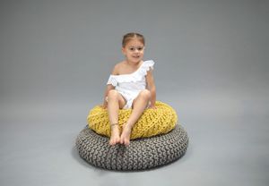Child Portrait backdrop grey.  Child sitting on grey and mustard/Yellow knitted cushions