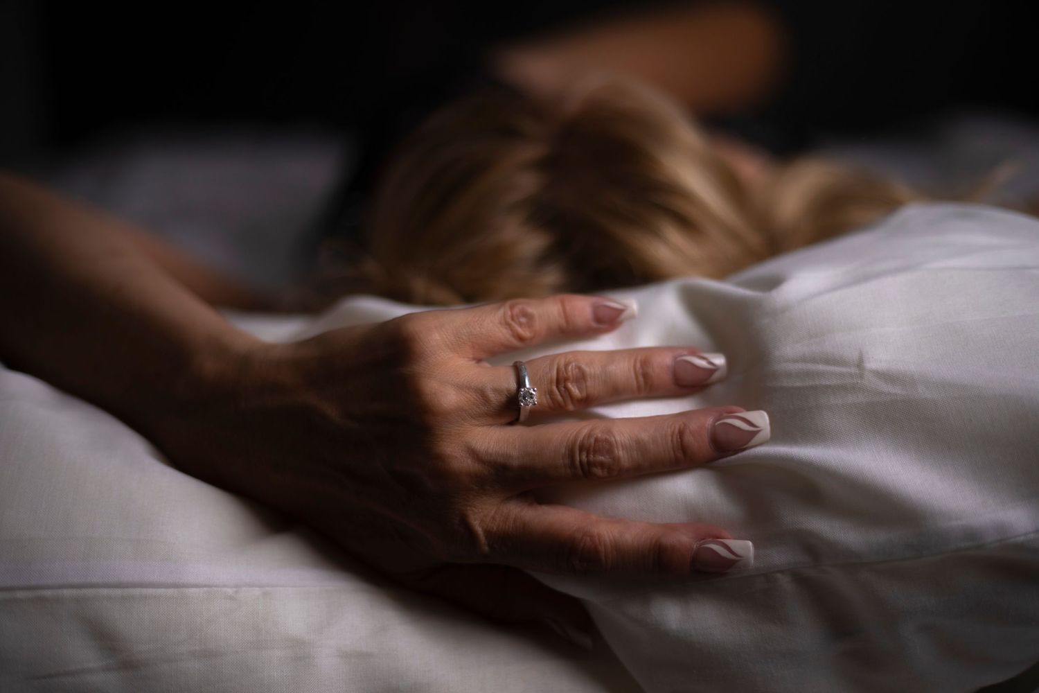 Sexy Boudoir Bride Photoshoot,  blonde woman in bed, hand above head image showing close-up of diamond engagement ring