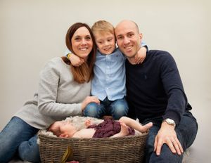 Family Photo shoot, Mother, Father, Son and Newborn Baby posed in basket
