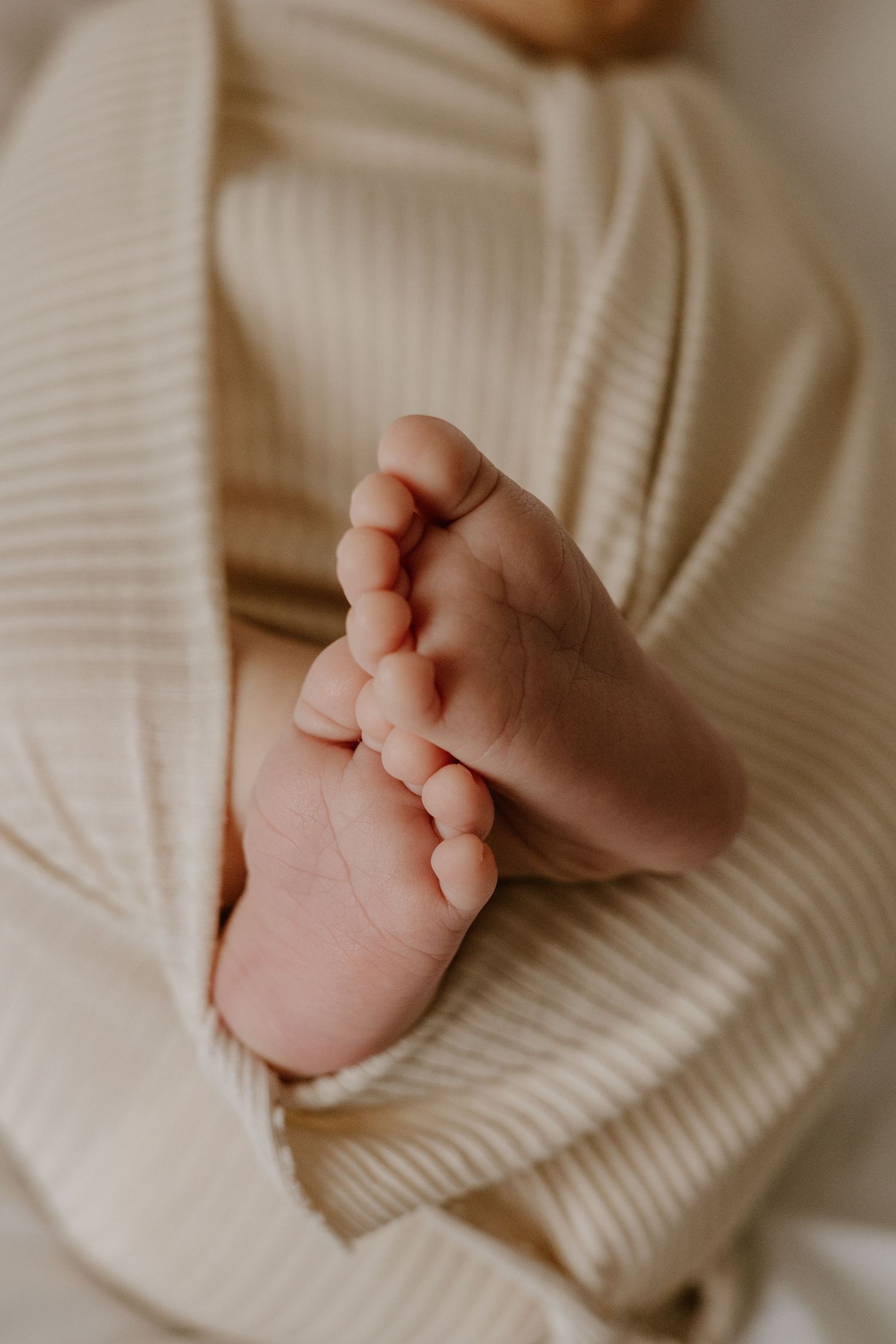 Close-up of gentle hands holding a soft white knitted fabric.