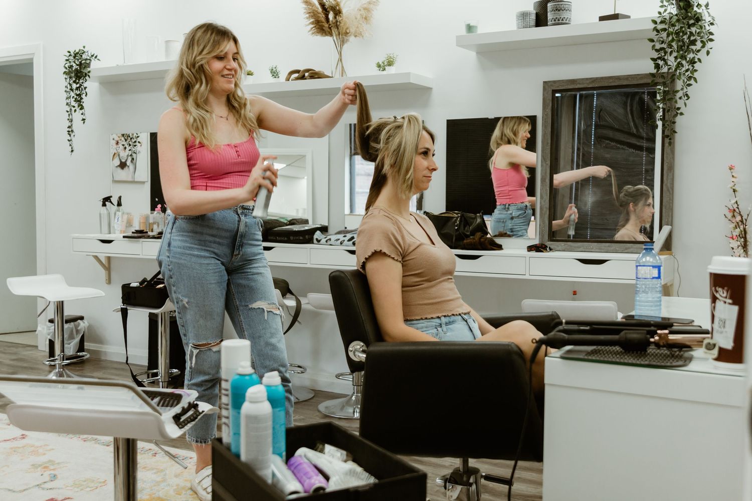 Salon scene with stylist working on client's hair in modern setting.