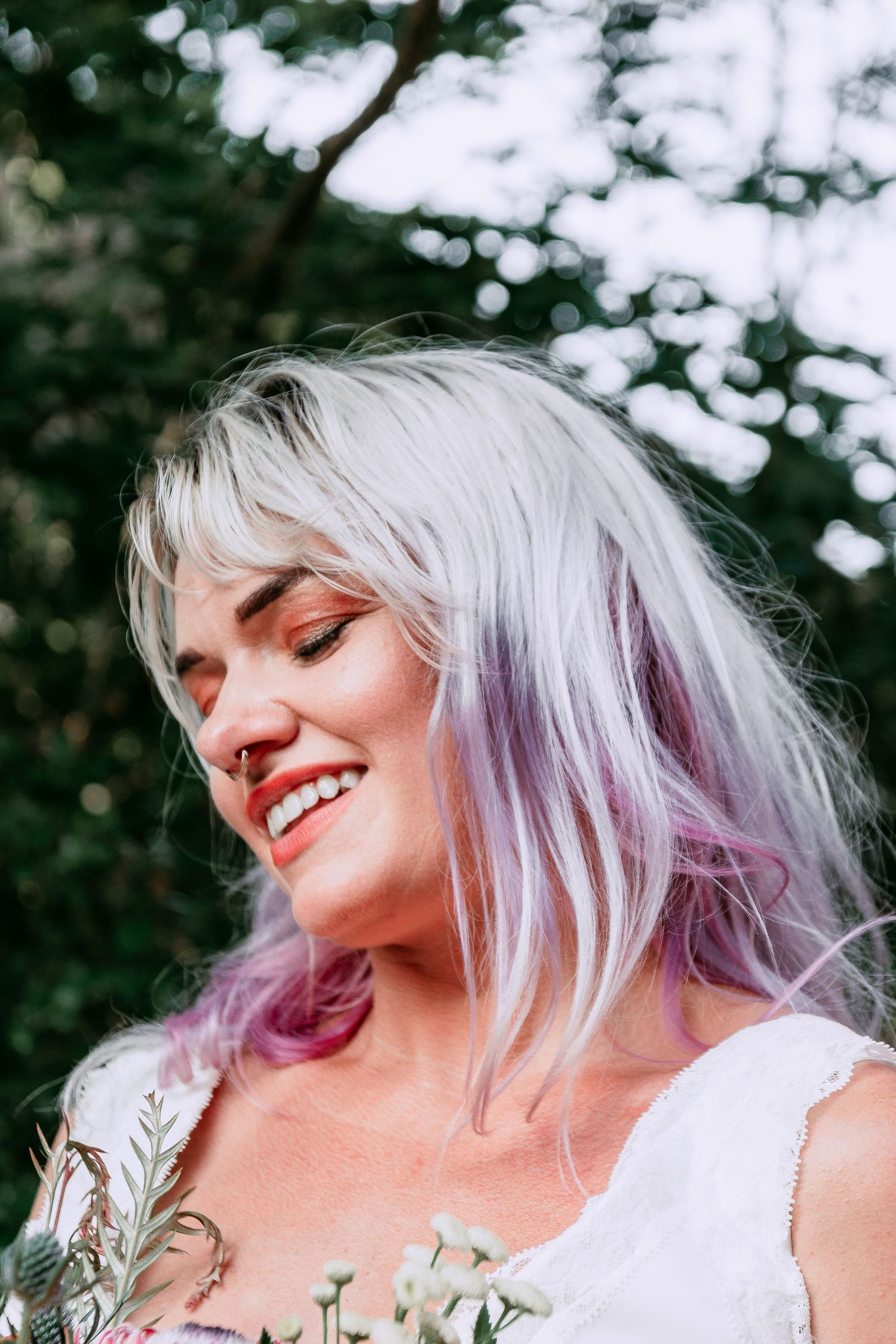 Portrait of girl holding bouquet looking down, smiling