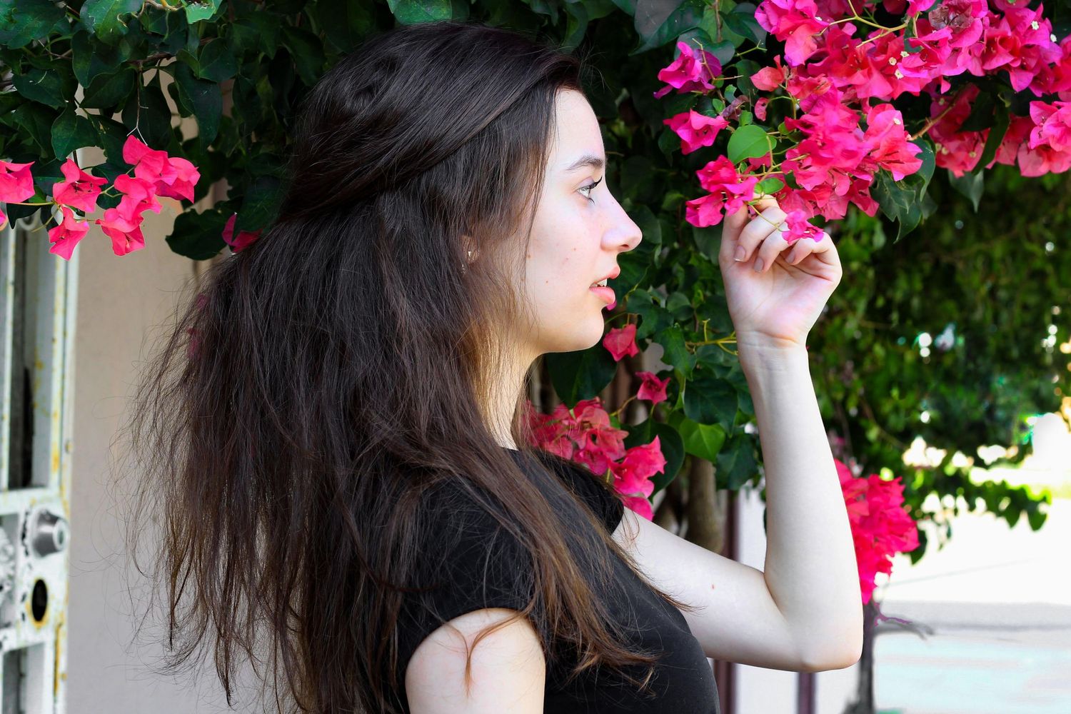 Side-profile of girl holding fushsia flower