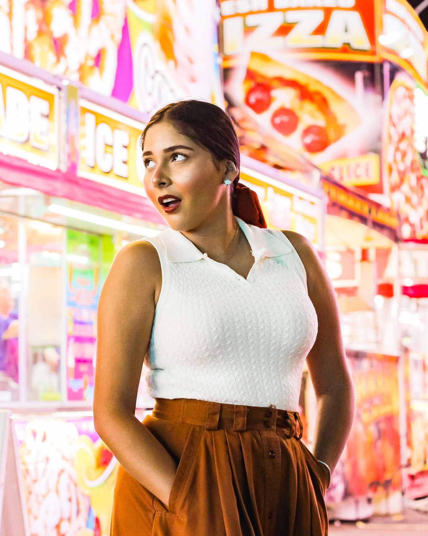 Girl standing in front of concession stands at a carnival