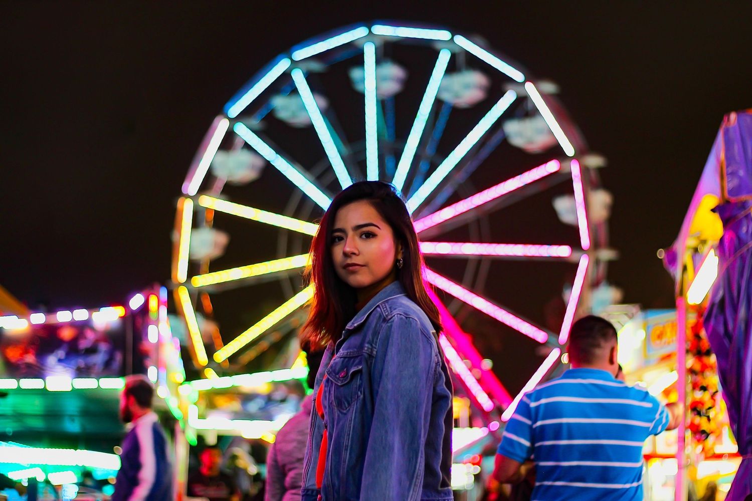 Girl in front of Ferris wheel at a carnival