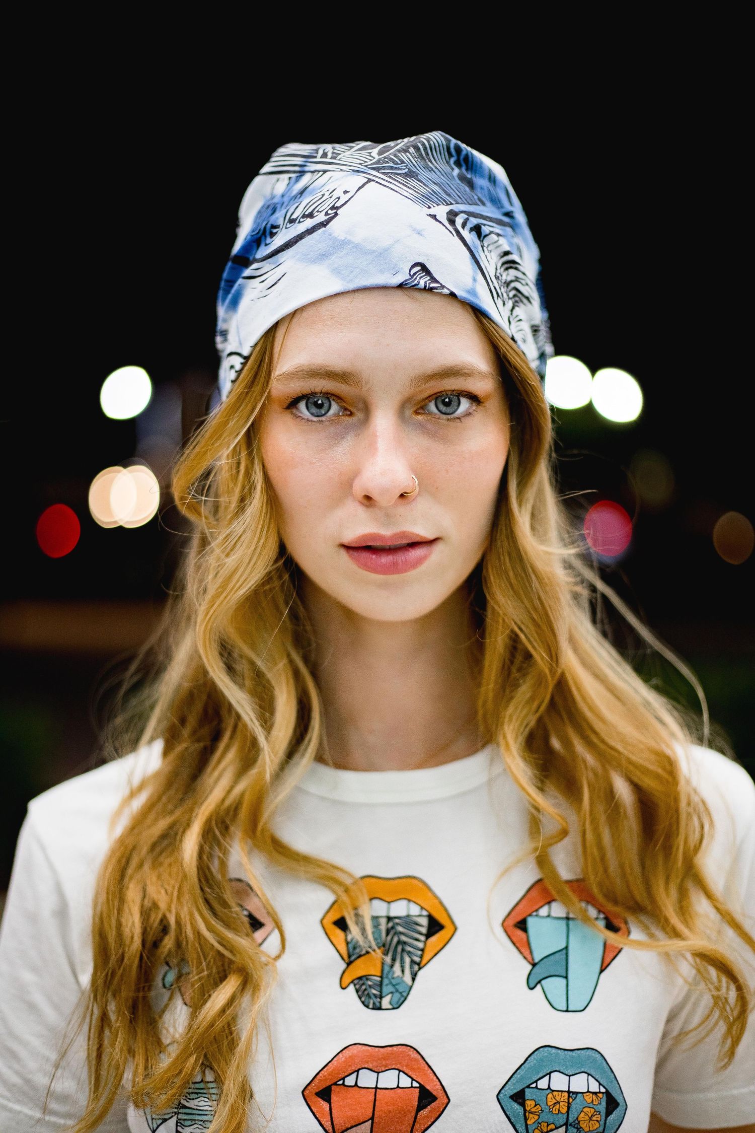 Portrait of a blonde girl at night with bokeh lights behind her