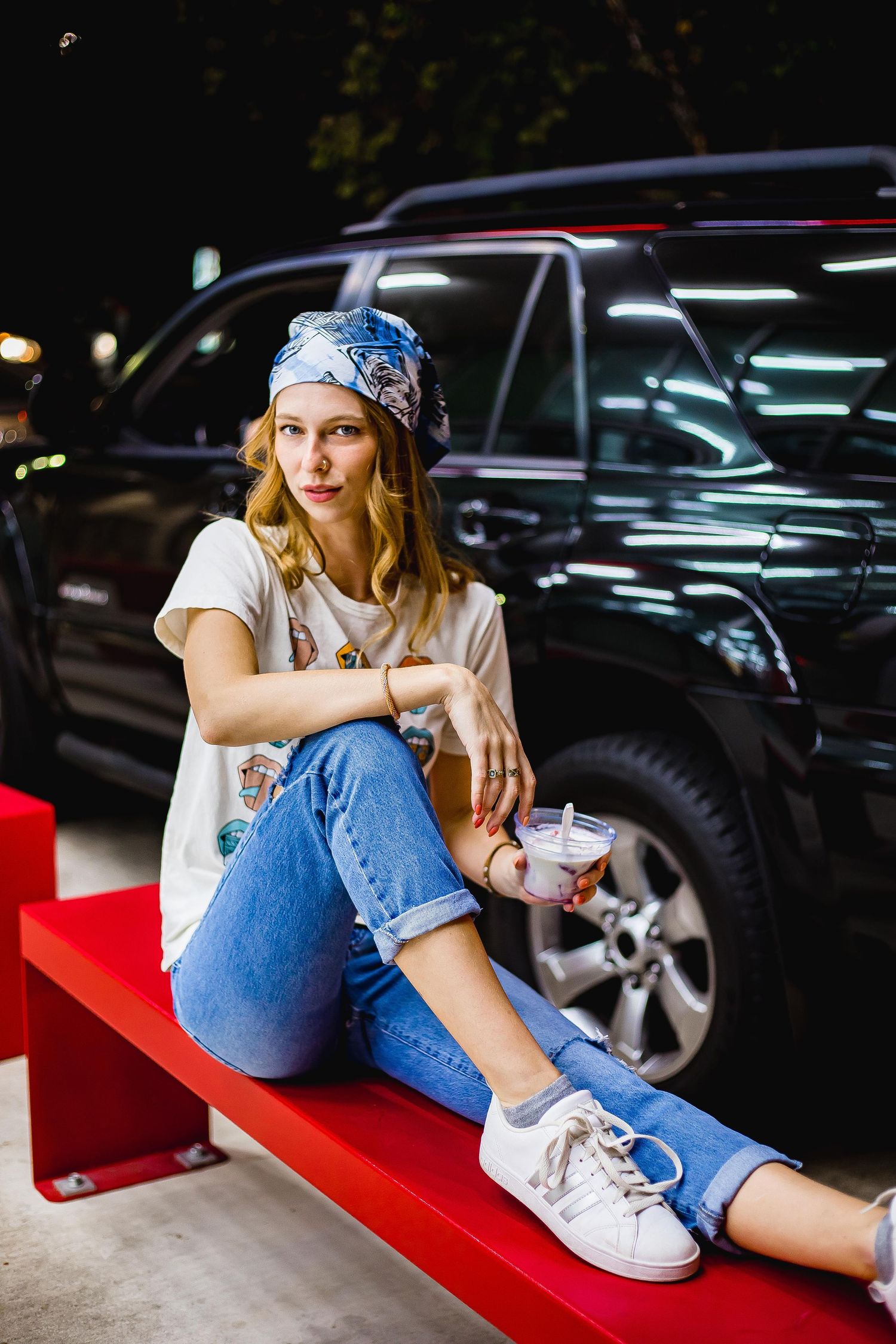 Girl posed with her arm on her knee on a bench
