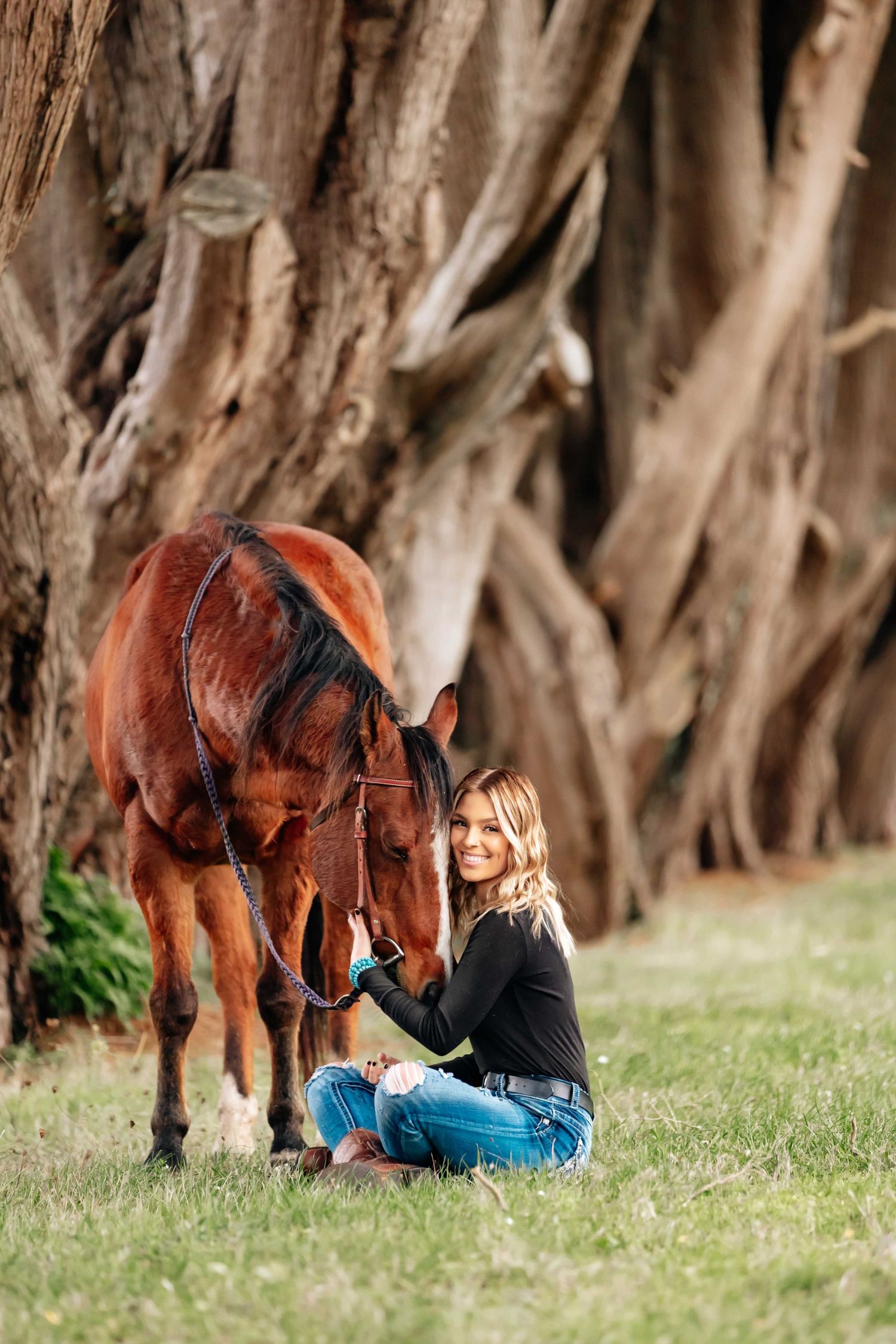 Teenage girl getting her senior portraits taken with her horse