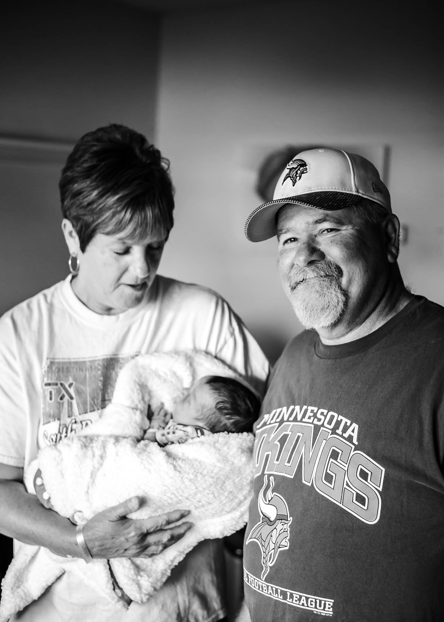 Proud grandfather and grandmother holding their new baby grandson a day after he was born in Sioux City, IA.