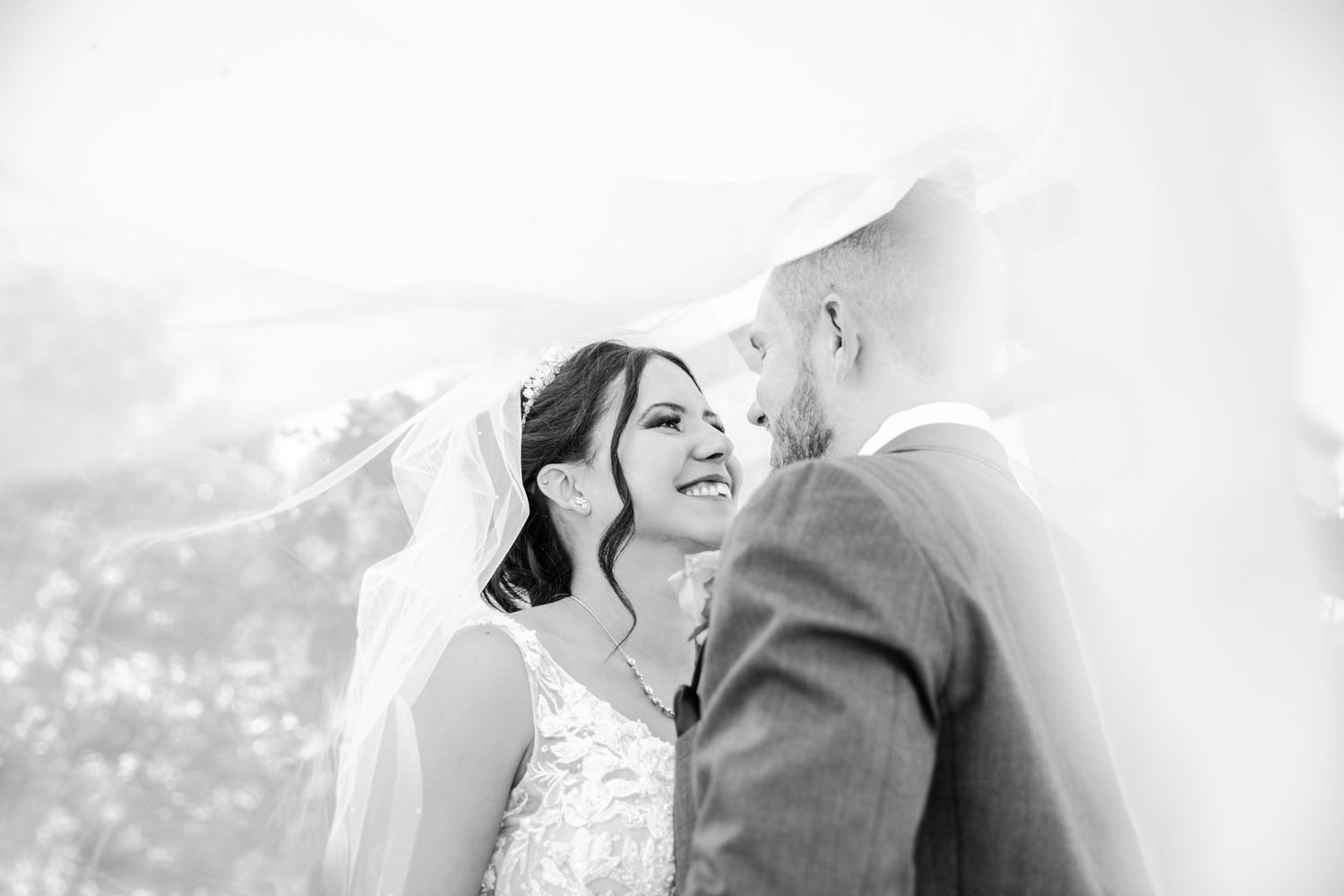 Black and white intimate wedding portrait capturing romantic moment in natural light.