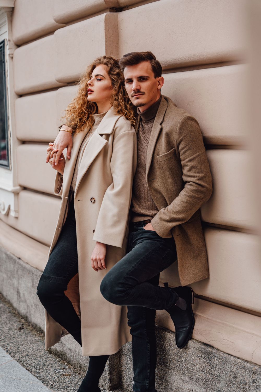 Lifestyle fashion photo shoot against beige wall featuring autumn outfits.
