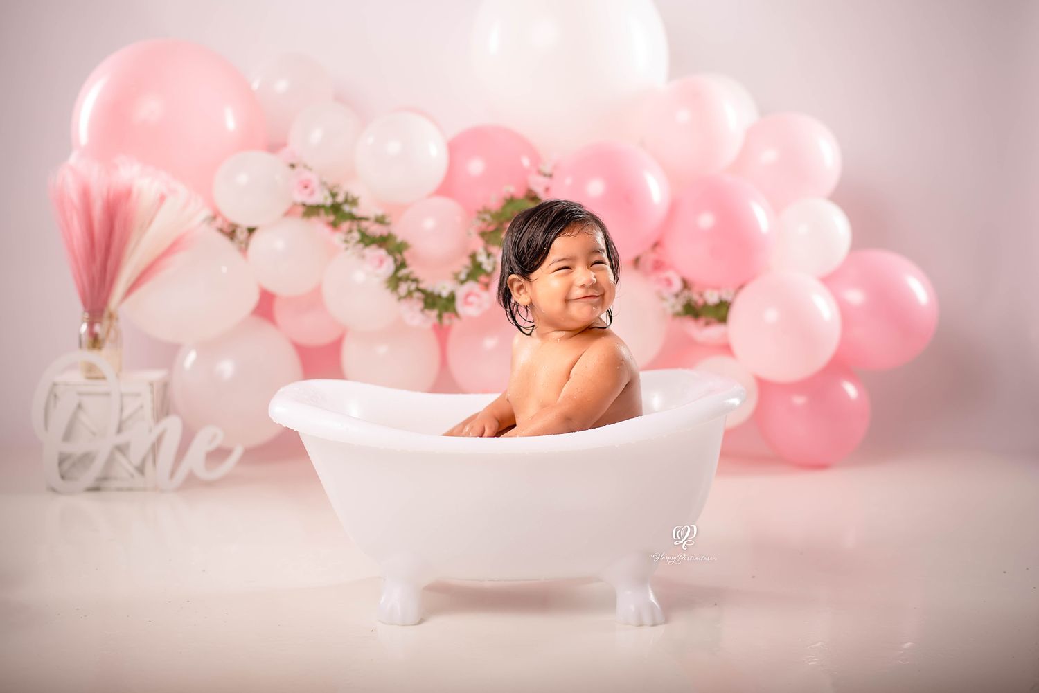 One year old baby girl splashing in tub birthday photos, pink & white balloons with leaves; South Carolina photographer