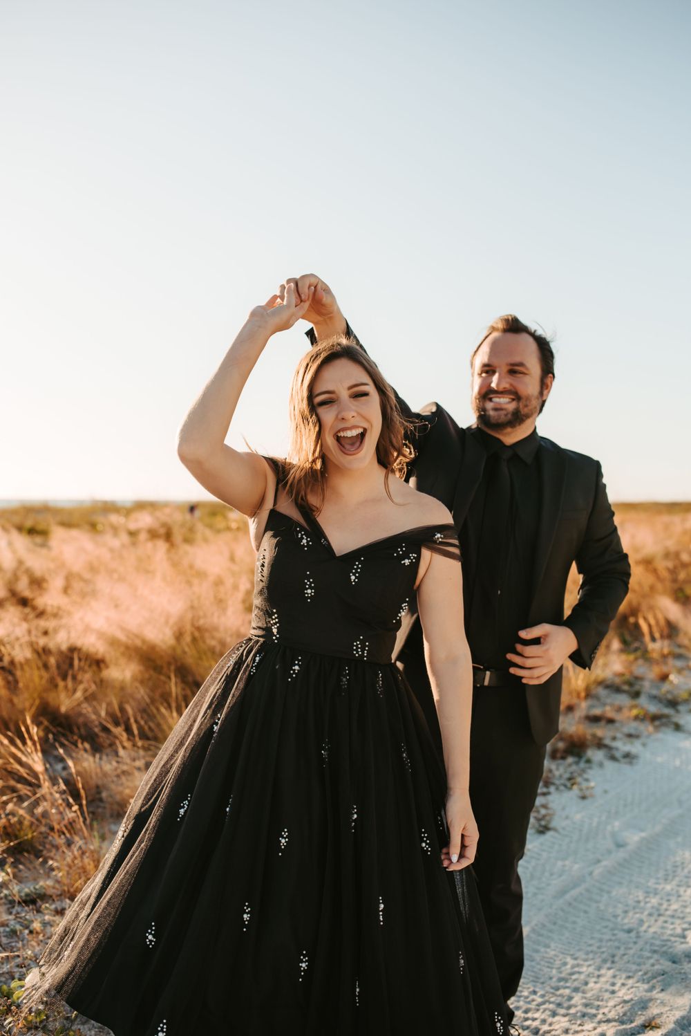 Man spins woman around while leading her by the hand.