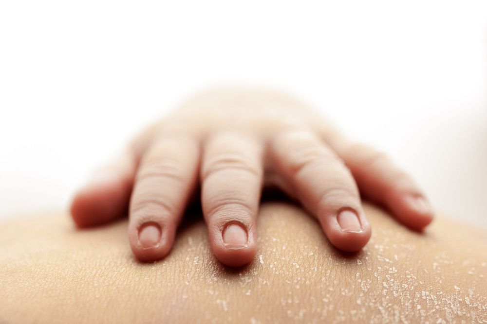 Tiny baby hand with delicate fingers resting on soft surface.