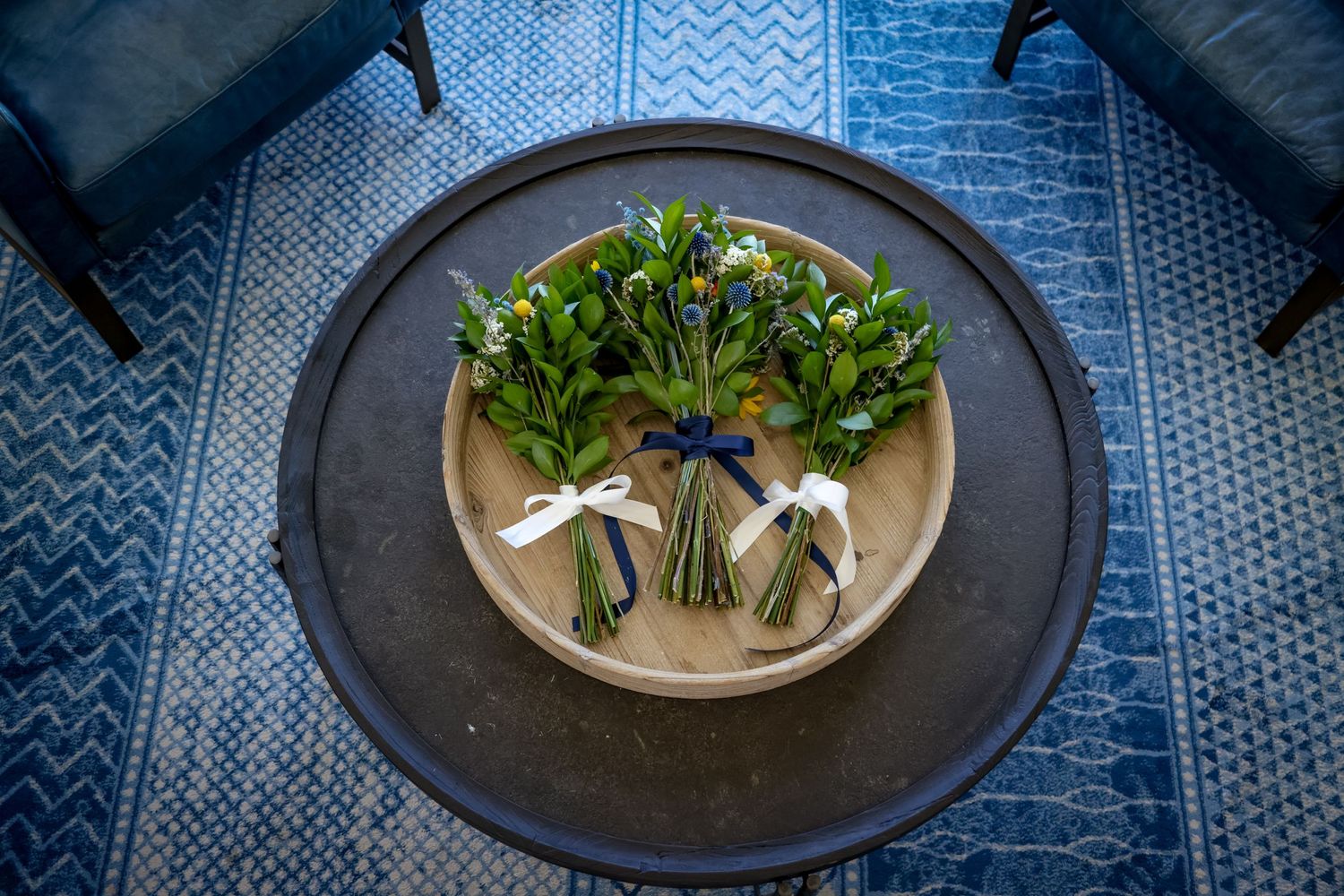 Wedding bouquet arrangements displayed on a dark plate against a blue patterned background.