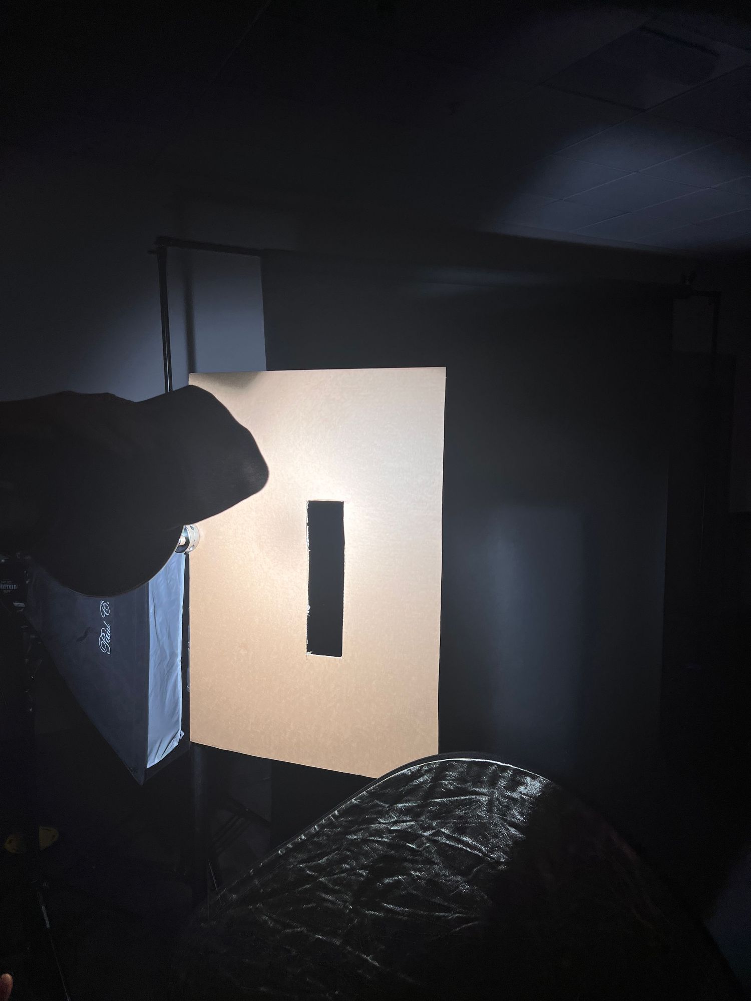 Behind-the-scenes photo studio setup with softbox lighting against dark background.