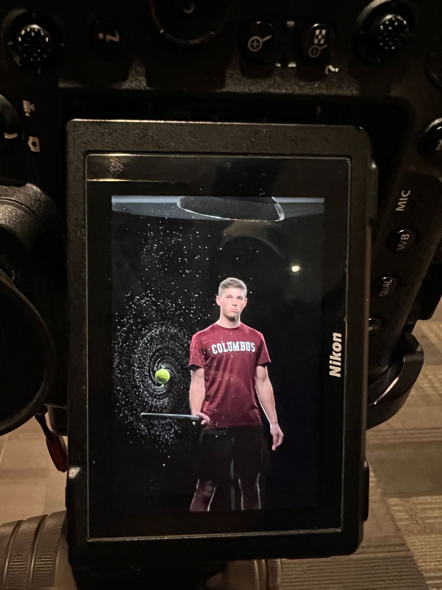 A digital display shows a photo shoot with special effects and lighting against a dark background.