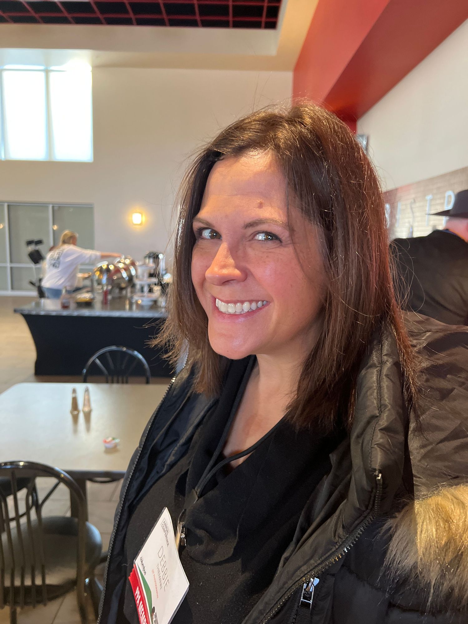 A candid indoor portrait showing a warm smile in natural lighting.