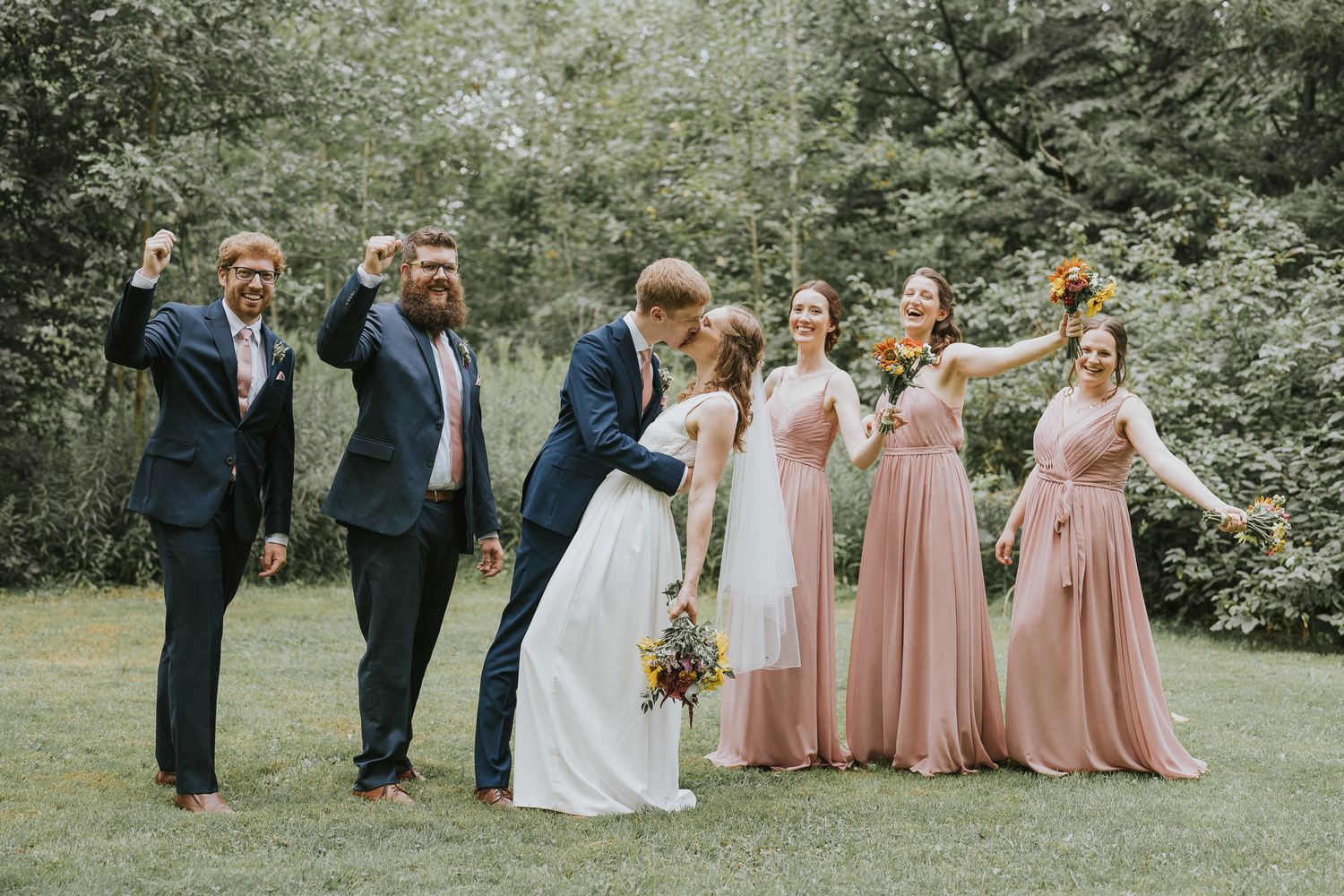 Groomsmen and Bridesmaid cheering at the newly weds