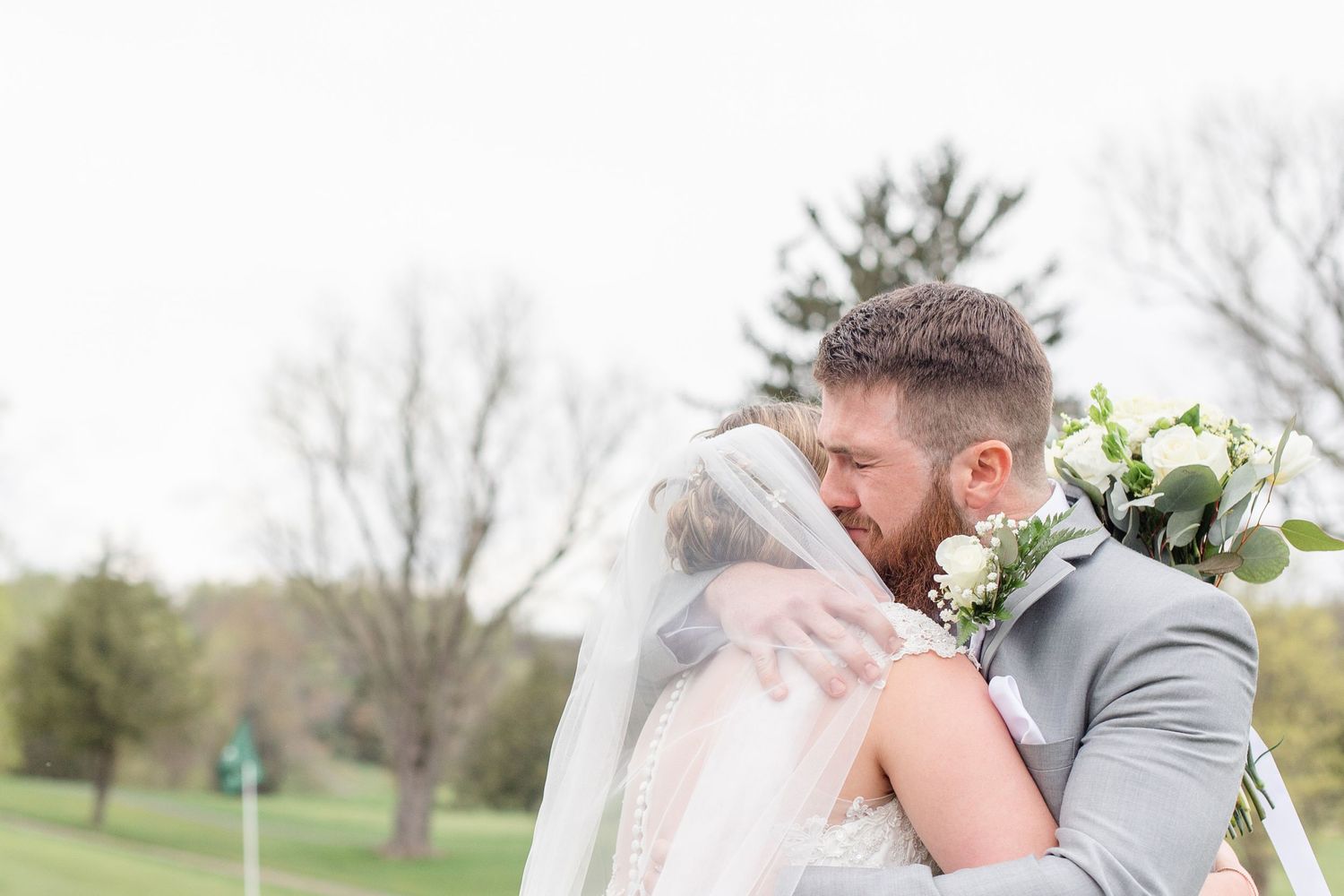 An intimate embrace between bride and groom during their outdoor wedding ceremony.