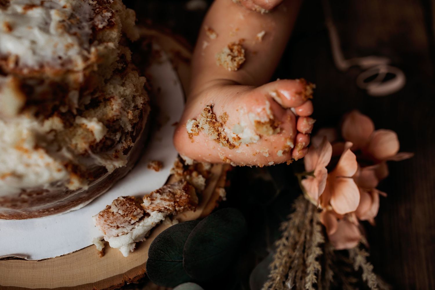 Close-up shots of hands and cake smashing during a first birthday celebration.
