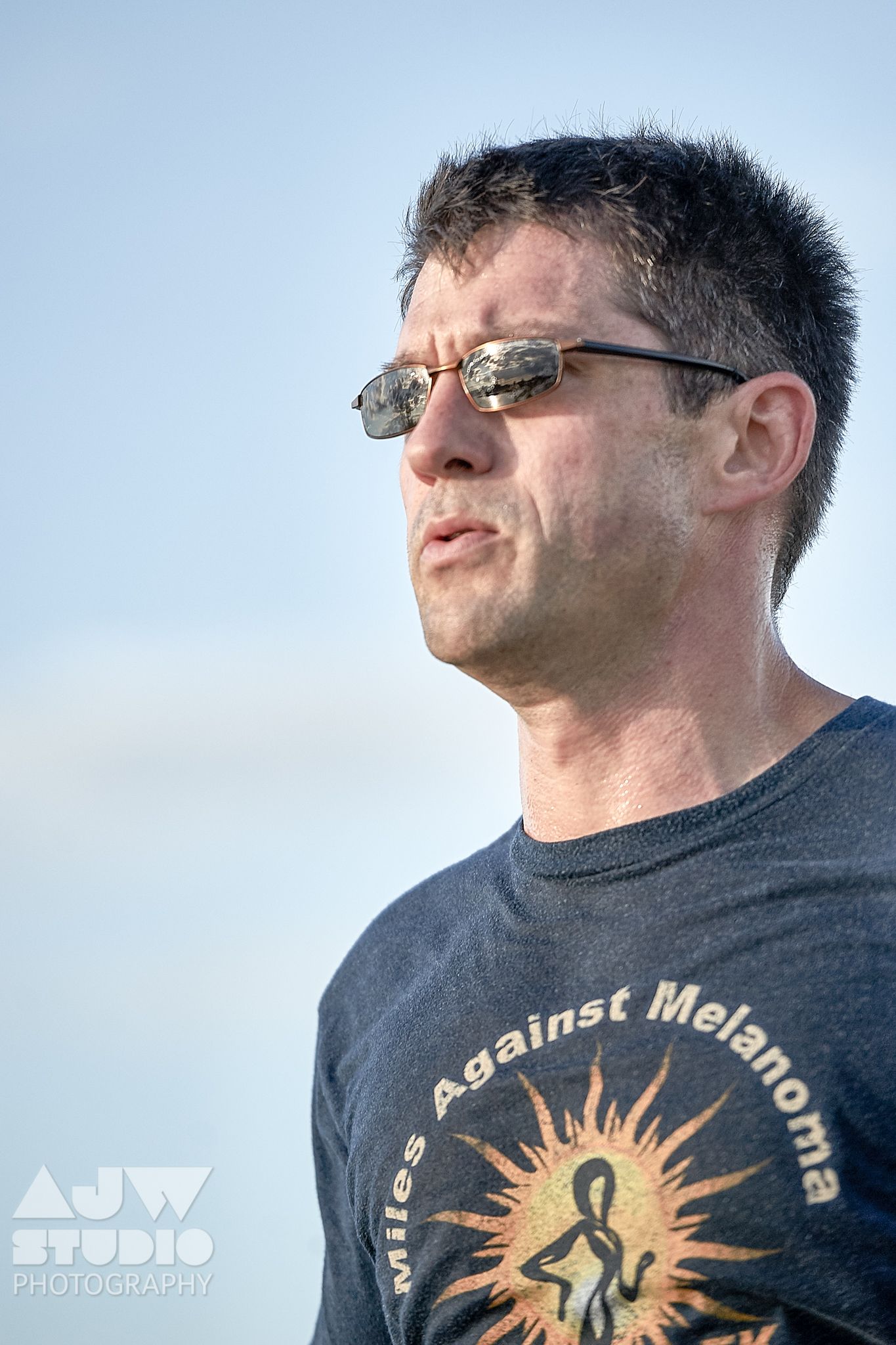 Close-up shot of a participant wearing an Against Melanoma t-shirt at an outdoor event.