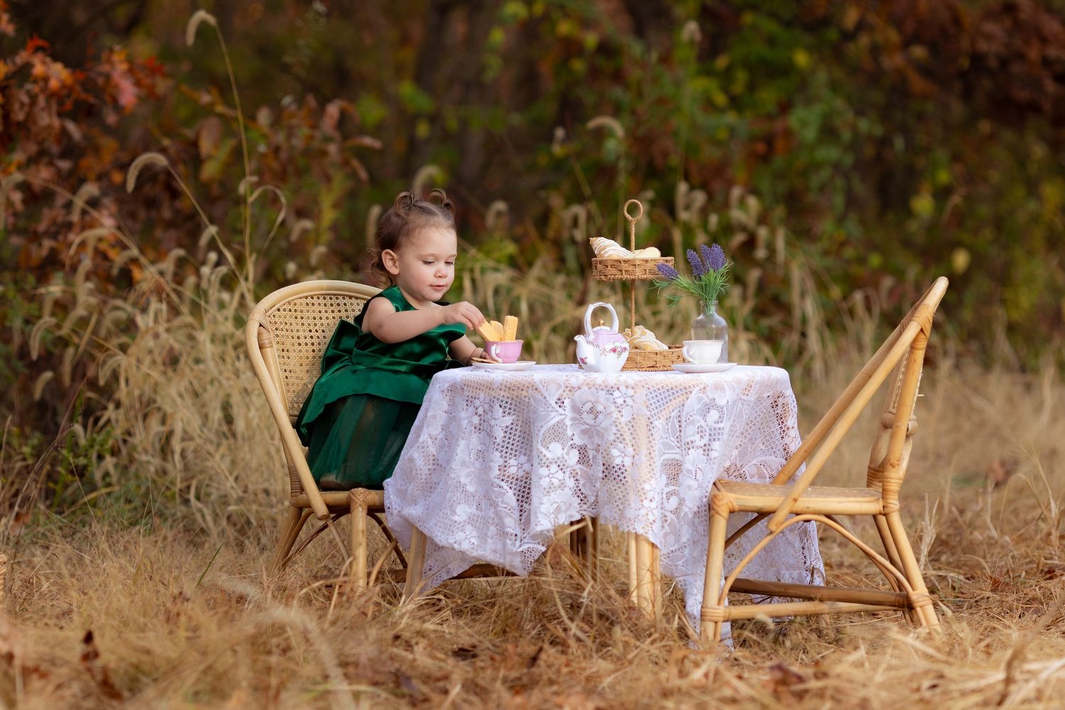 A toddler having a tea party in the Illinois countryside on a pretty fall day.