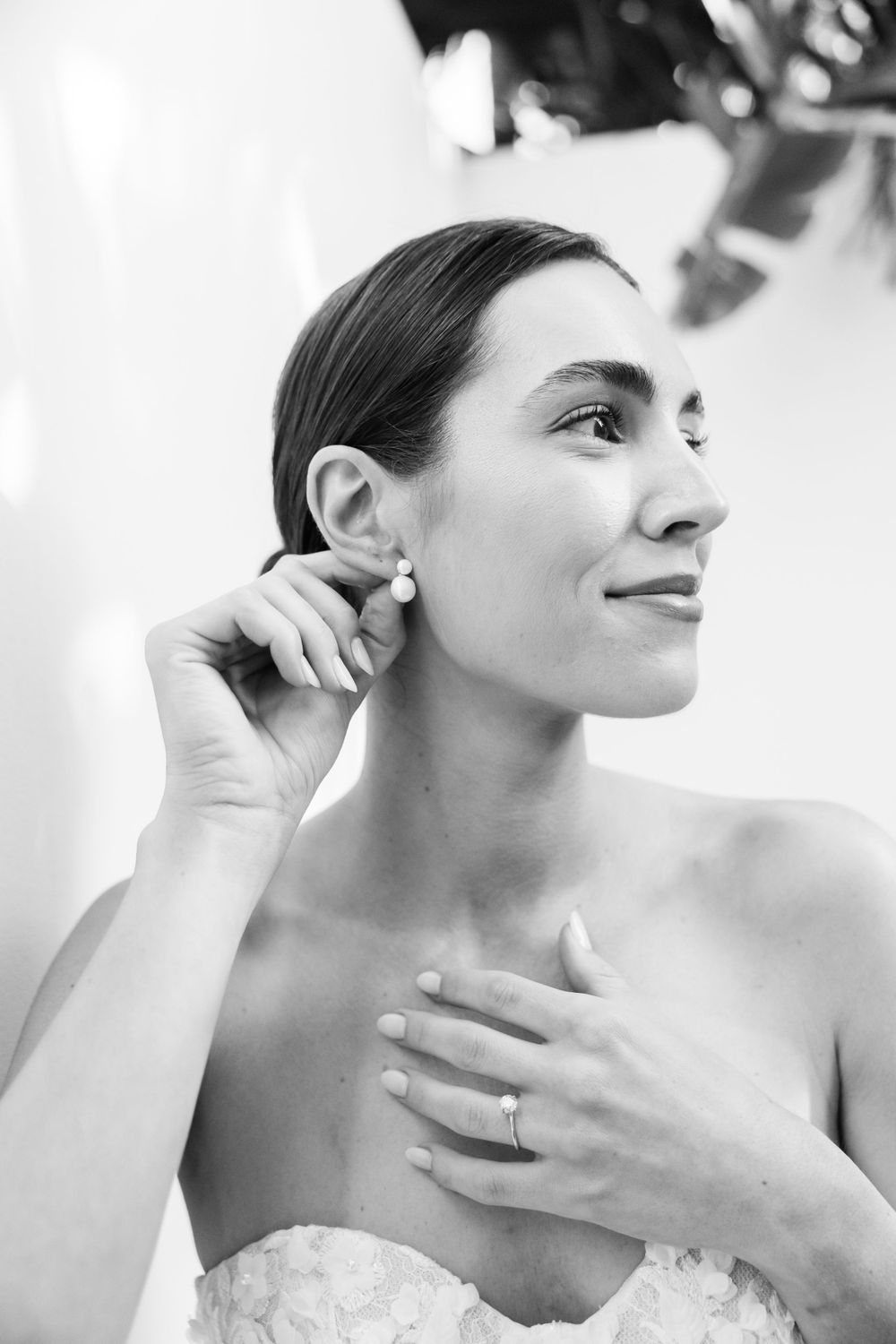 Black and white portrait showing elegant bridal jewelry and strapless gown details.