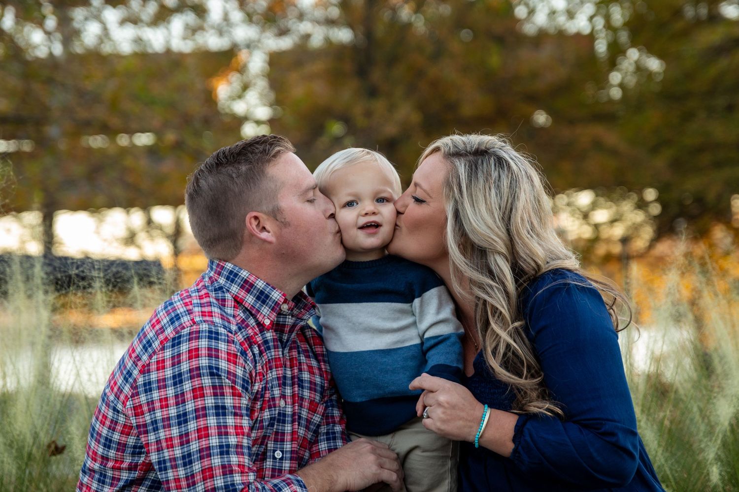 Family portrait session in golden autumn field at sunset.