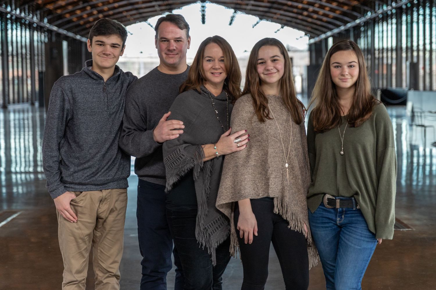 A group photo taken indoors with an industrial-style ceiling and modern decor.