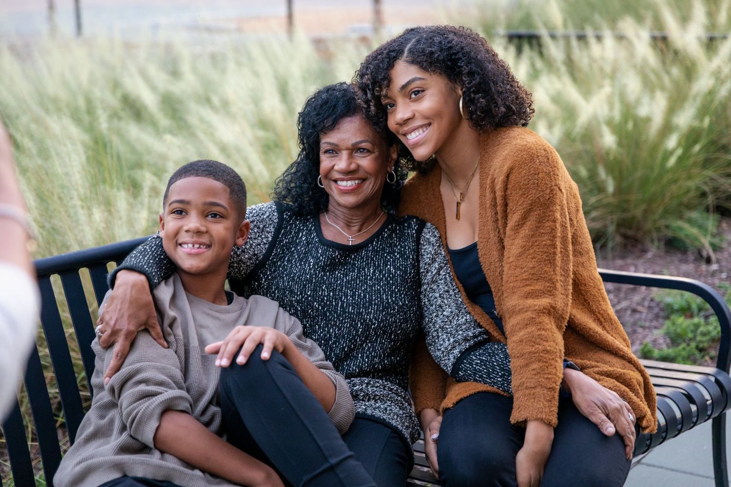 Family portrait session in natural setting with warm autumn colors and casual styling.