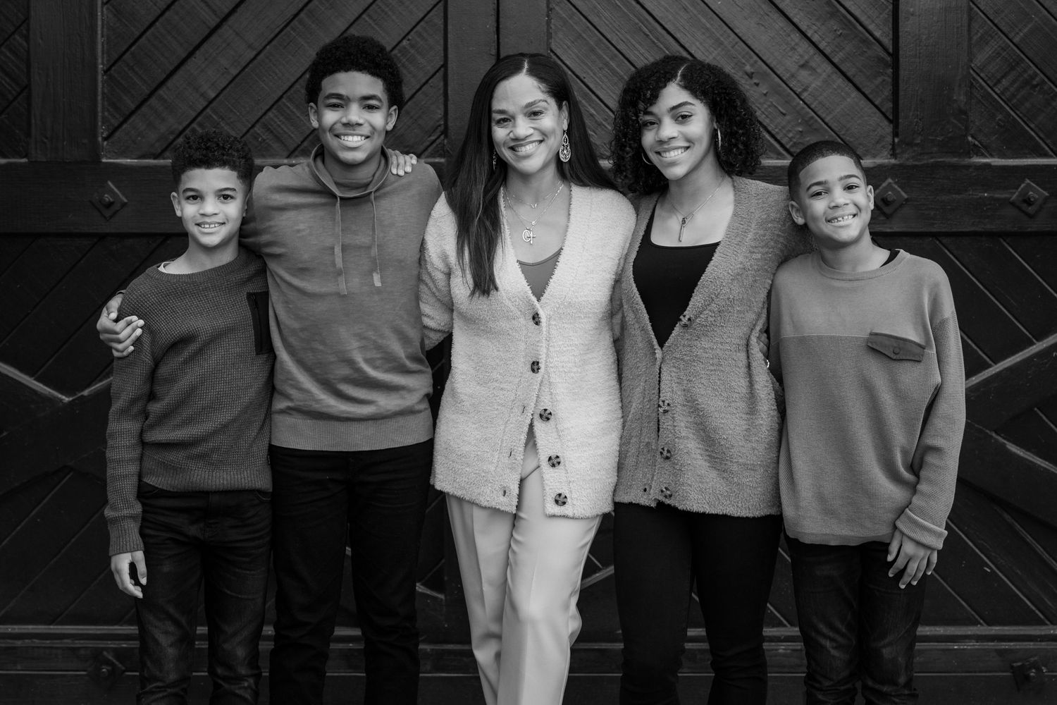 Black and white family portrait session against industrial door background.