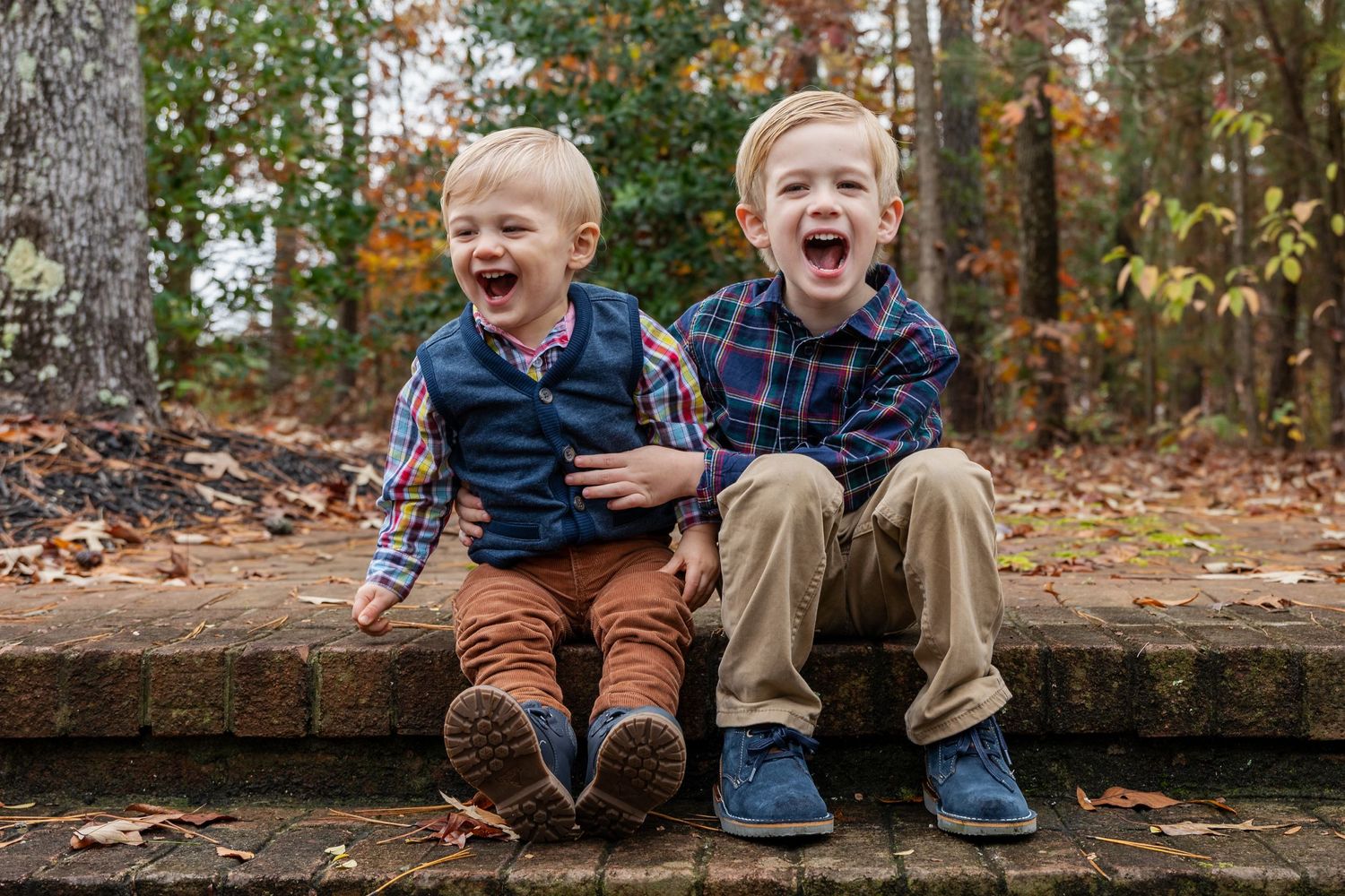 Joyful expressions captured during autumn family photo session on brick wall.