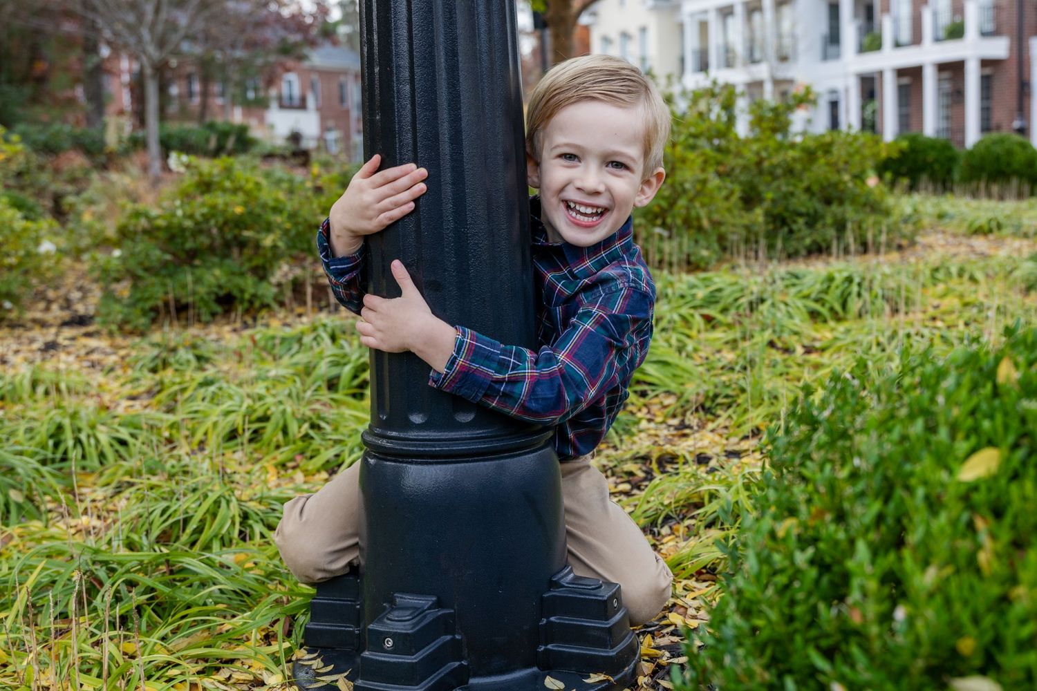 Playful outdoor photo session with family members posing by black metal fence.