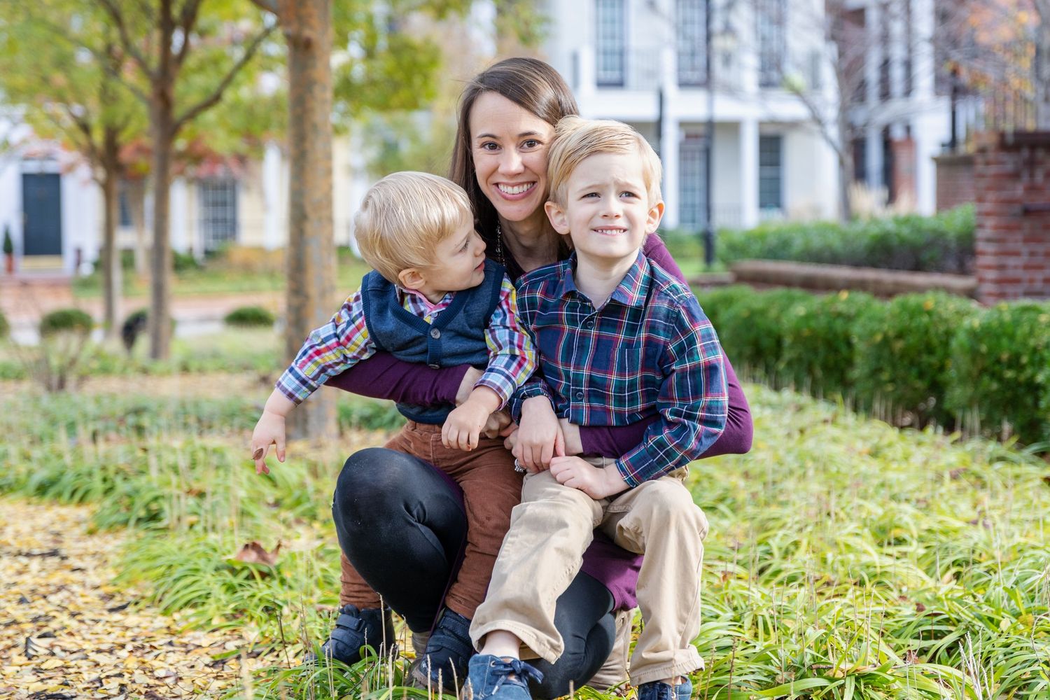 Candid outdoor family portraits taken in front of historic buildings with autumn foliage.