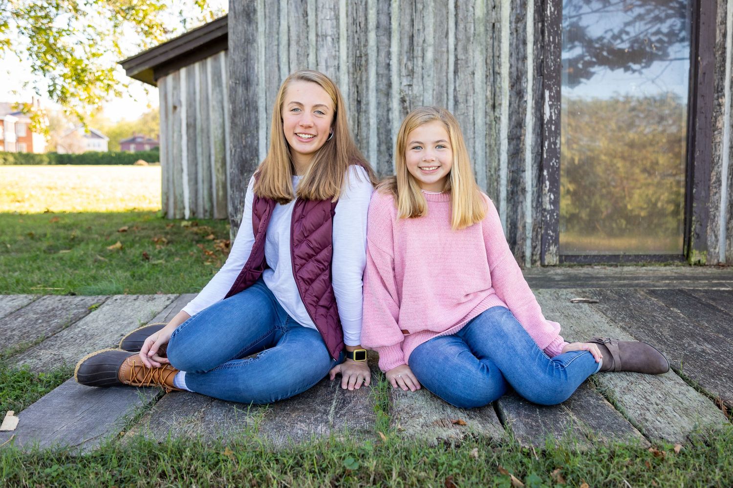 Casual outdoor portraits taken on a wooden deck with natural autumn scenery in the background.